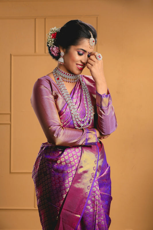 a woman in a purple and gold sari