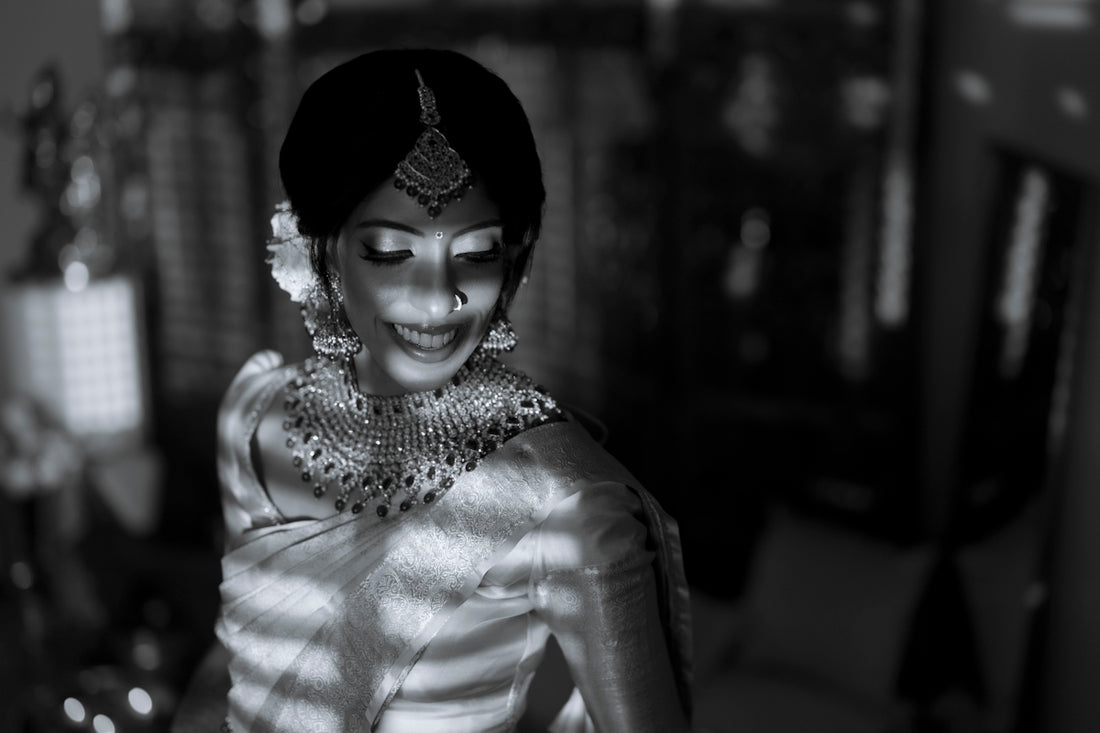 A bride in traditional indian attire with ornate jewelry.