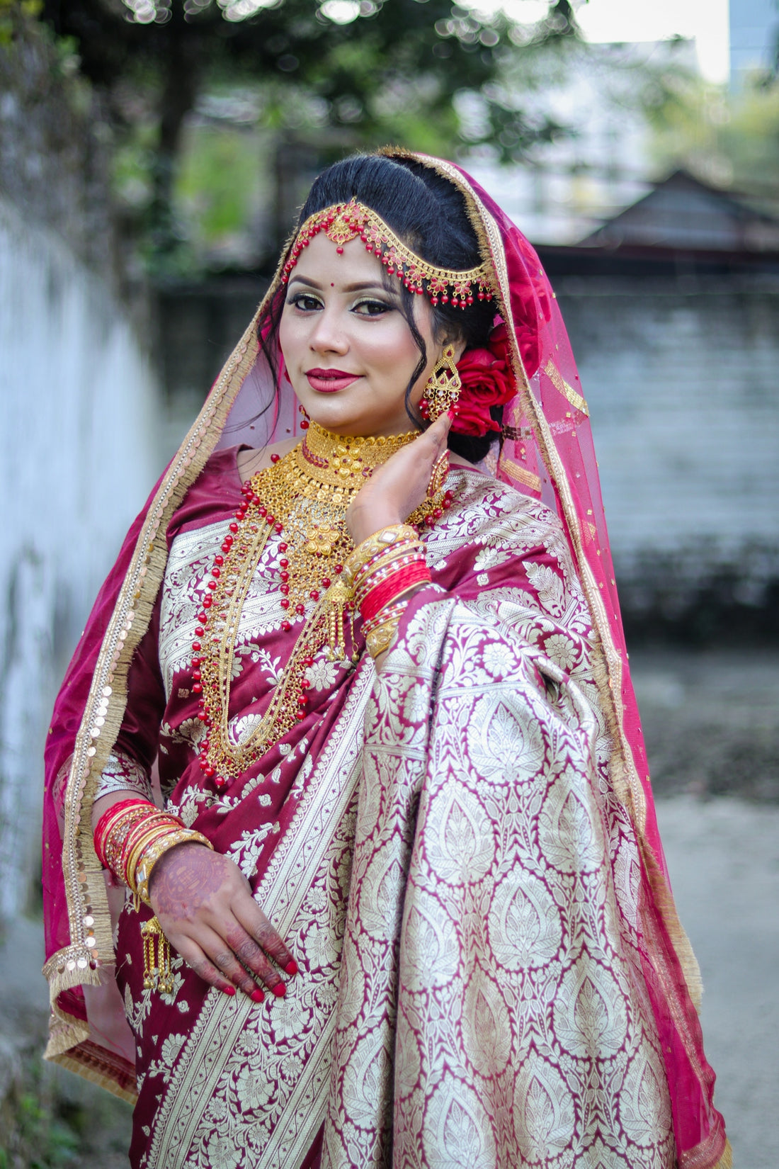 A bride in a traditional maroon and gold sari