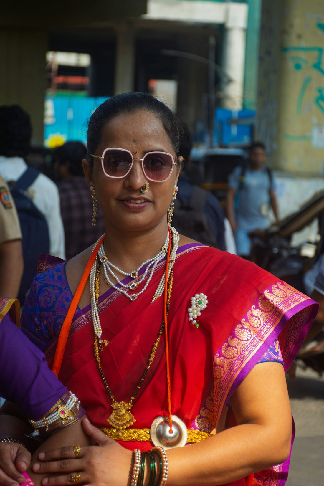A woman wearing a red sari and traditional jewelry.