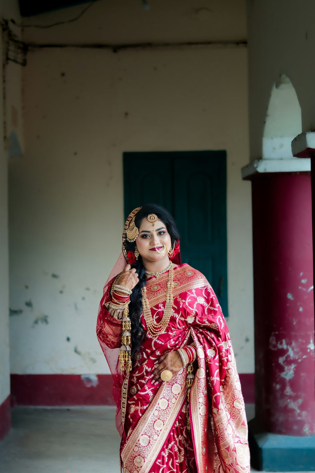 Elegant woman in red traditional dress and gold jewelry.