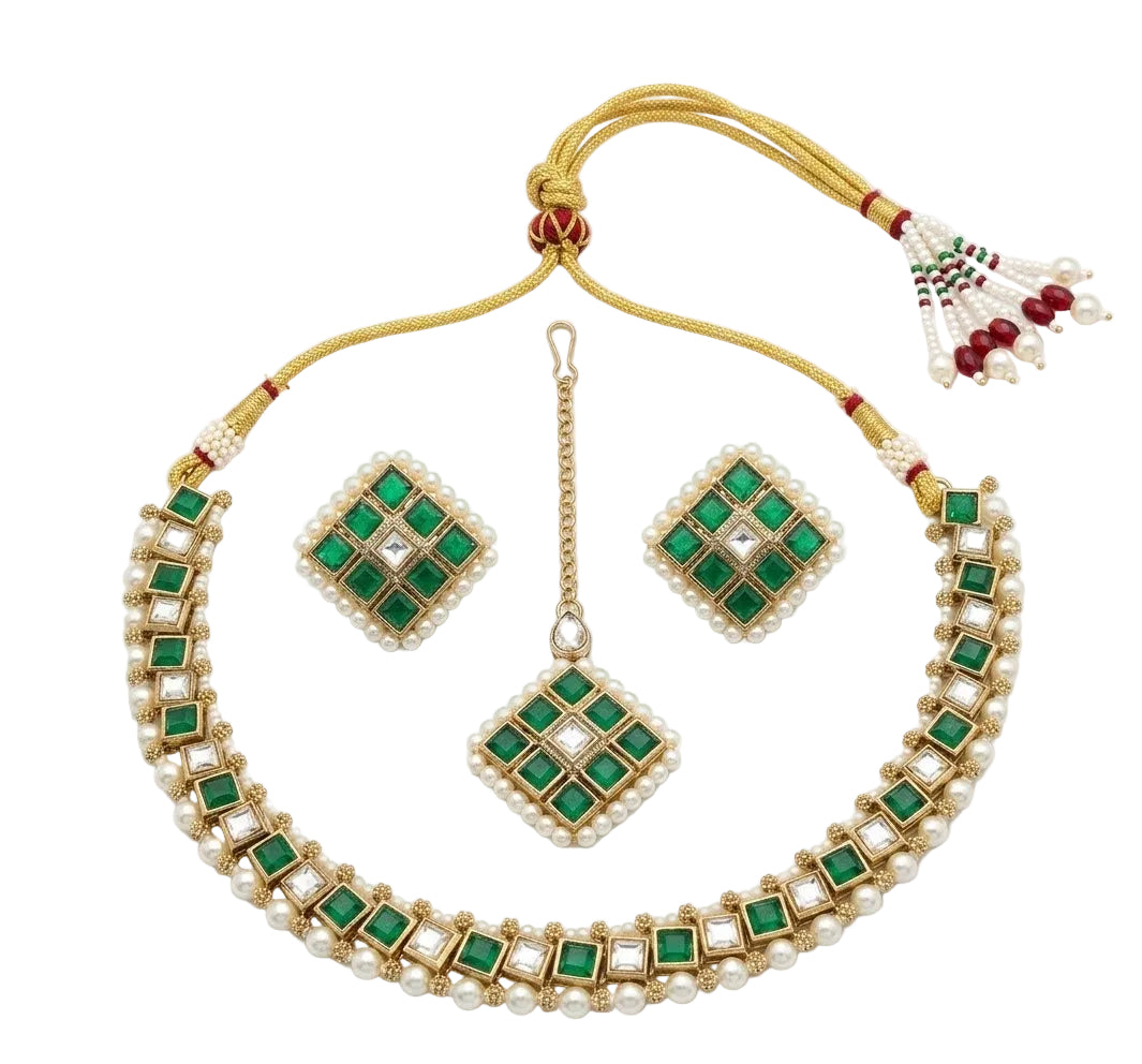 Symmetrical top-down view of an artificial Kundan choker necklace, two matching earrings, and a maang tikka with emerald green square stones and pure white pearl accents on a plain white background.