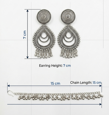 Silver-toned traditional Indian jhumka earrings with a matching chain, shown with dimension lines indicating a height of 7 cm and a chain length of 15 cm.