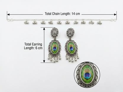 Silver-toned traditional Indian jhumka earrings with peacock feather inlays, shown with a matching chain and measurement annotations indicating a total chain length of 14 cm and total earring length of 6 cm.