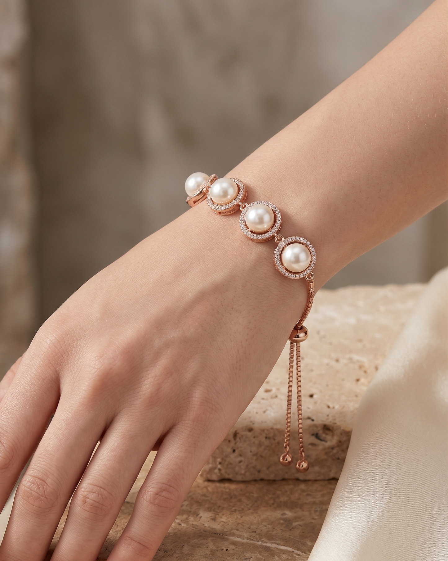 Close-up flat lay of the rose gold adjustable slider bracelet featuring cultured pearls and fine box chain.