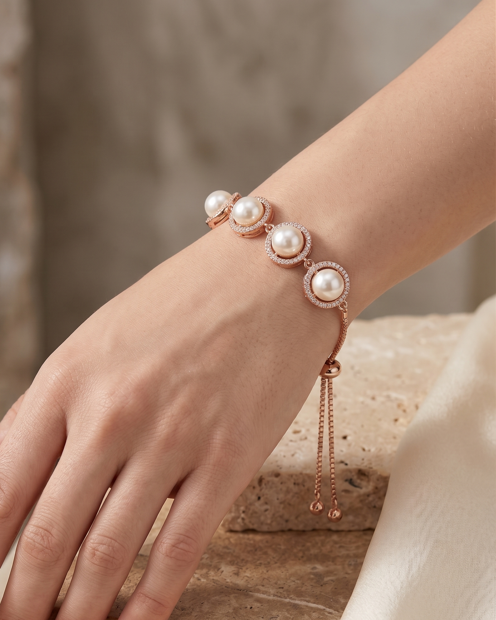 Close-up flat lay of the rose gold adjustable slider bracelet featuring cultured pearls and fine box chain.