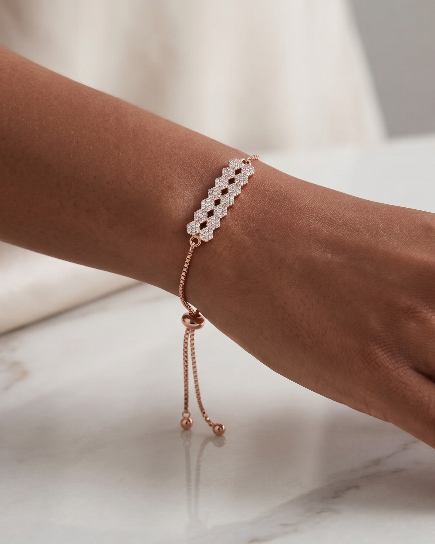 Model wearing the elegant rose gold geometric pavé bar adjustable bolo bracelet, demonstrating the beautiful drape of the box chain.