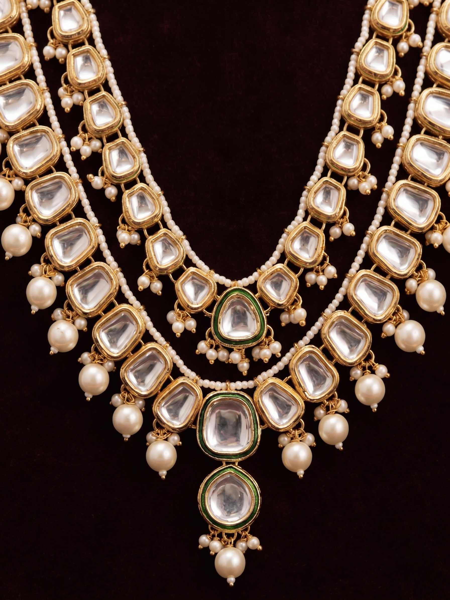 Close-up detail of the imitation clear stones, green enamel trim, and faux pearl tassels on the artificial Kundan jewelry pieces.