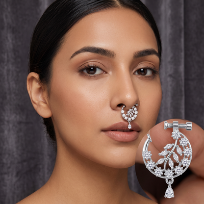 Woman wearing a silver nose ring with a matching earring against a dark background