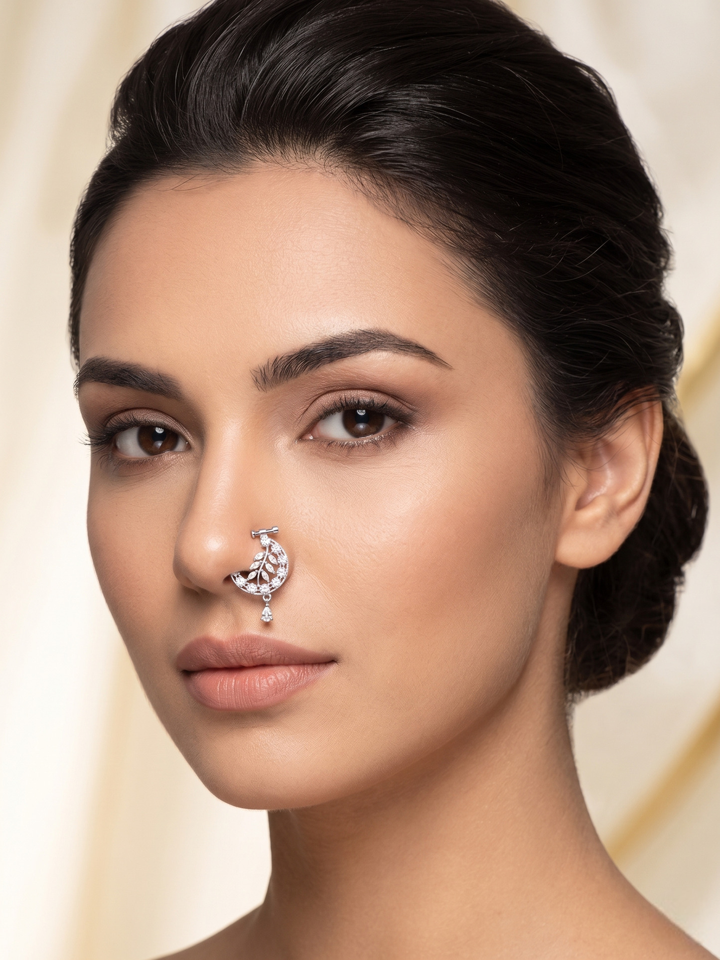 Woman wearing a nose ring with a beige background