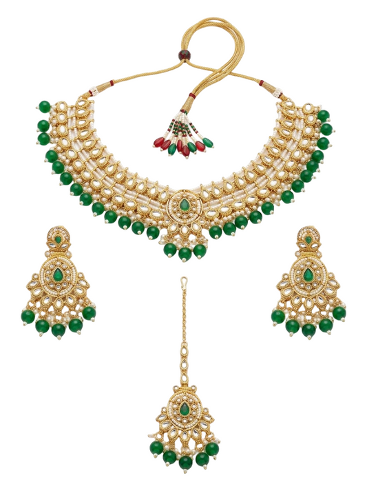 Gold and white pearl traditional Indian jewelry set featuring a collar necklace, matching dangle earrings, and a maang tikka, decorated with green stones and red bead accents, shown on a plain white background.