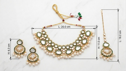 Gold-toned traditional Indian jewelry set with a necklace, matching earrings, and a maang tikka, shown on a light marble background with dimension lines and measurements.